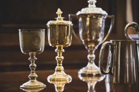 The Master’s gold goblet and the Wardens’ three silver goblets on a polished table.