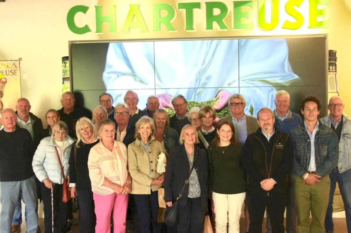 Members of the Livery Court standing in front of a Chartreuse sign