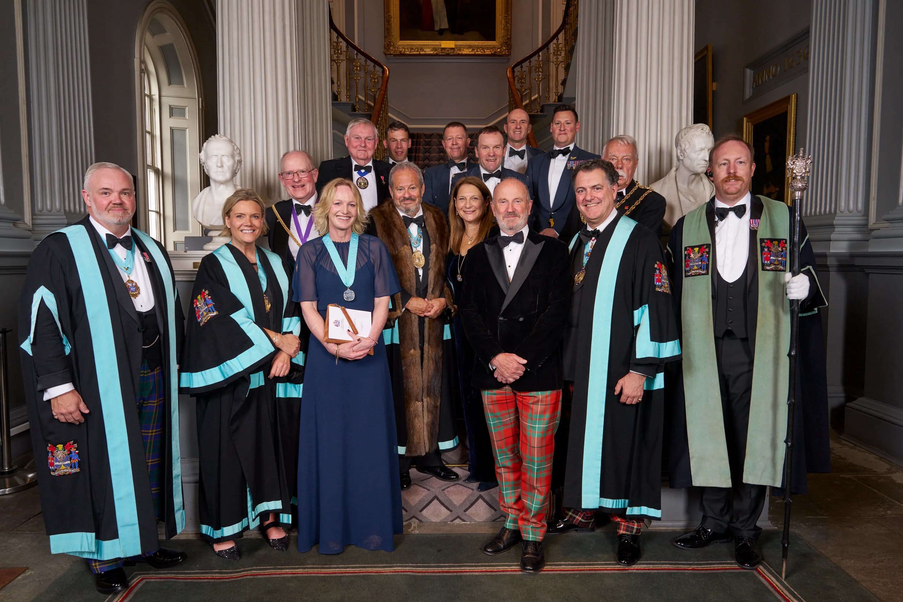 The Company and guests in livery gowns on the staircase at the Scotland Dinner